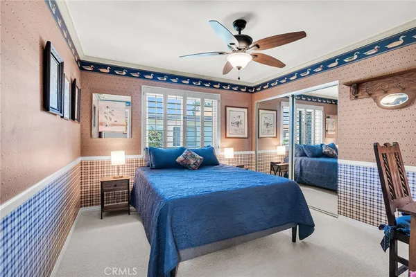 a bedroom with a bed a chandelier and dresser