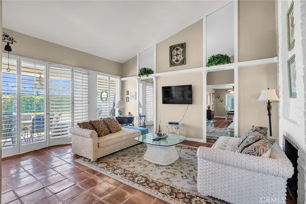 a living room with furniture a flat screen tv and a large window