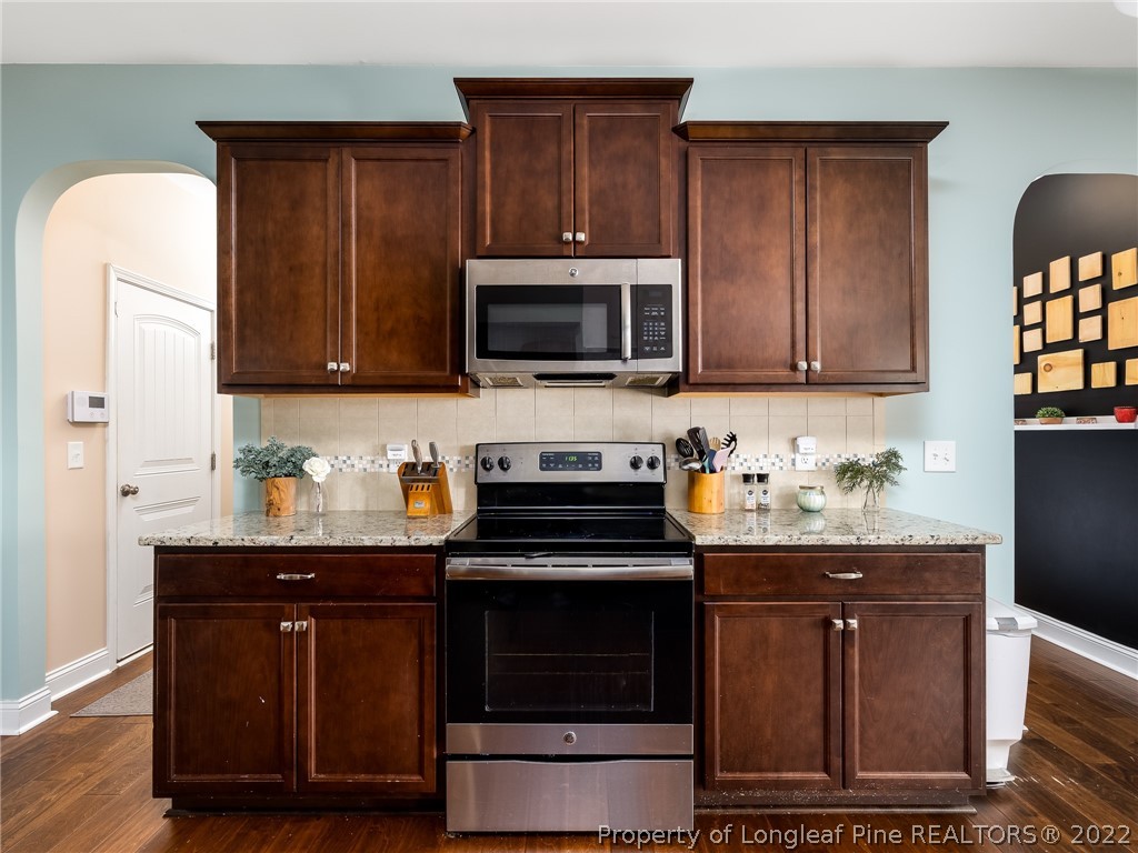 5137 Boxcut Lane Hope Mills, NC 28348 - Photo 12 of 48 a kitchen with granite countertop wooden cabinets and stainless steel appliances