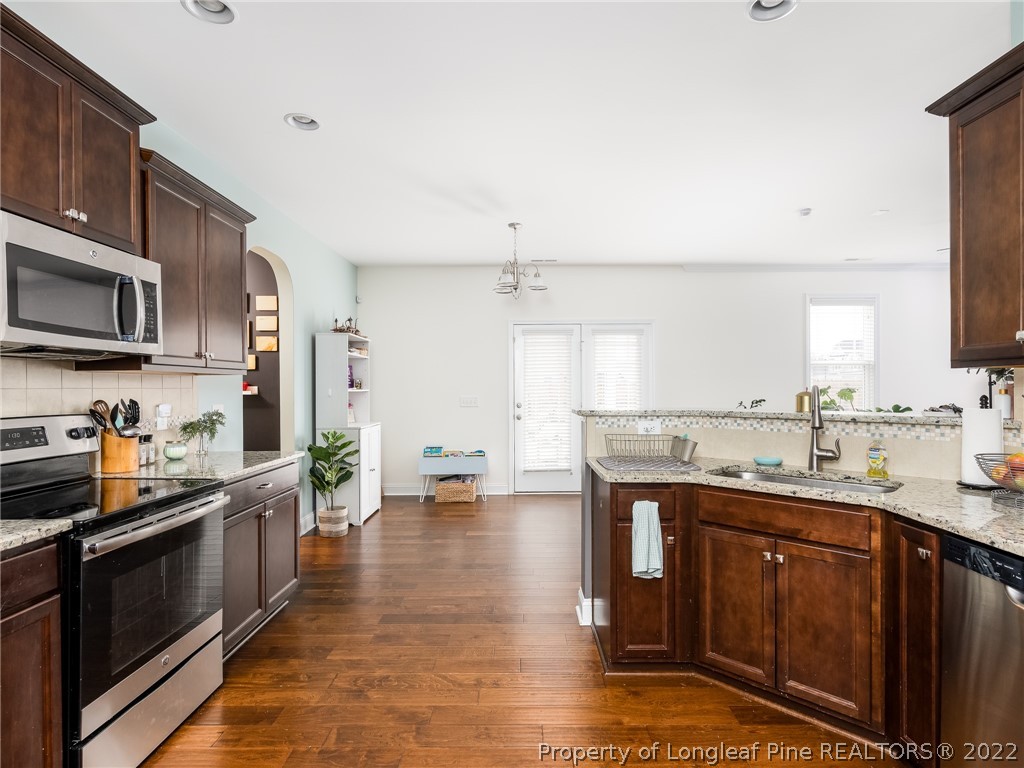 5137 Boxcut Lane Hope Mills, NC 28348 - Photo 14 of 48 a kitchen with stainless steel appliances a sink a stove top oven a counter space and cabinets