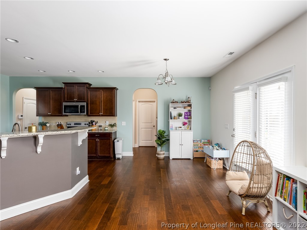 5137 Boxcut Lane Hope Mills, NC 28348 - Photo 15 of 48 a living room with stainless steel appliances furniture a fireplace a flat screen tv and wooden floor