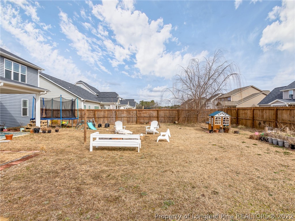 5137 Boxcut Lane Hope Mills, NC 28348 - Photo 45 of 48 a view of a yard with a table and chairs under an umbrella