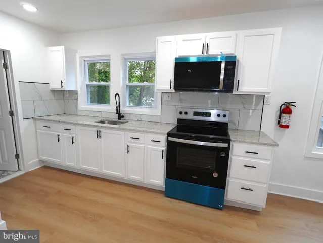 a kitchen with stainless steel appliances a stove sink and microwave