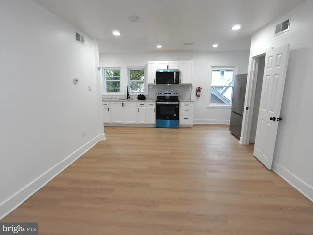 a view of a kitchen with refrigerator stove microwave and cabinets