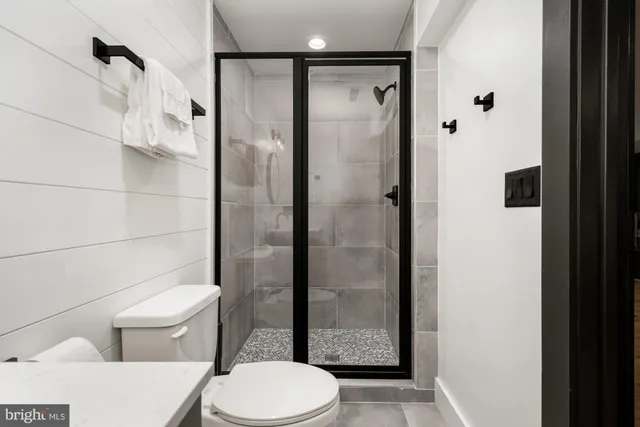a bathroom with a white tub a mirror and a shower