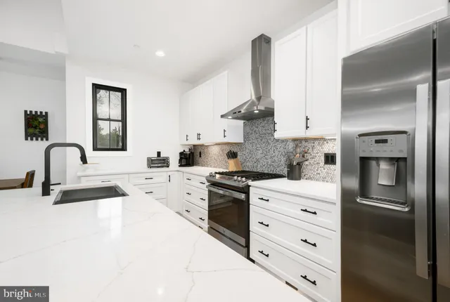 a kitchen with white cabinets and appliances