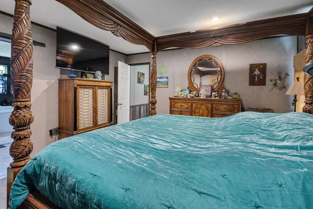 a bedroom with a bed and a large window