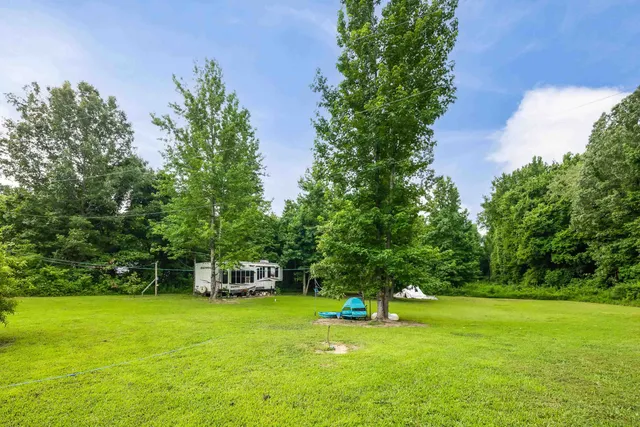 a view of a big yard with a house in the background