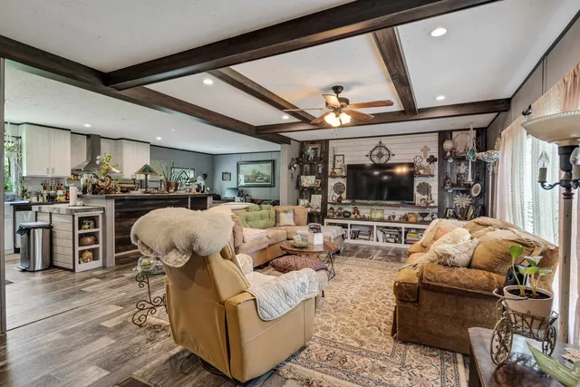 a living room with furniture a flat screen tv and kitchen view