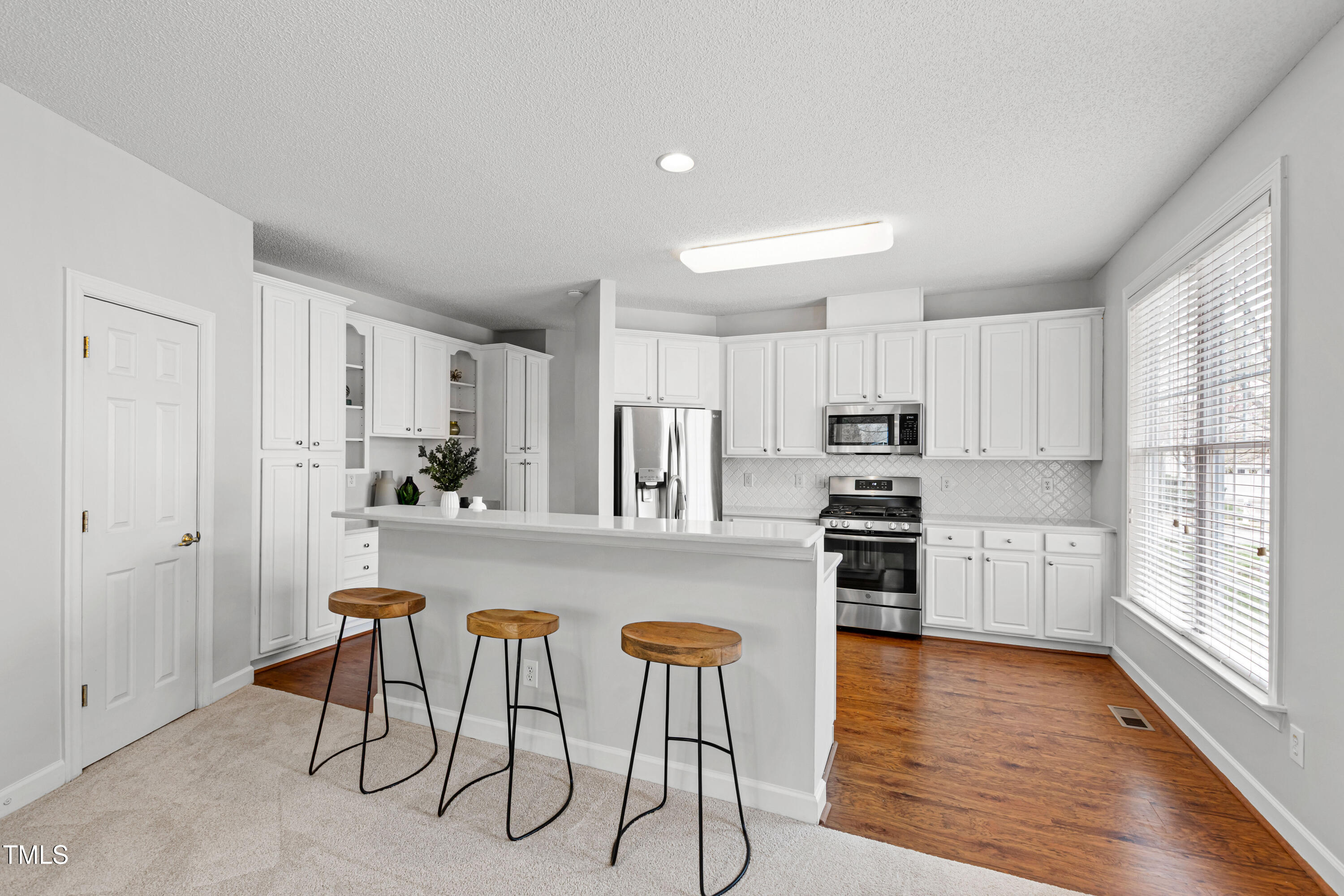 2024 Heritage Pines Drive Cary, NC 27519 - Photo 13 of 31 a kitchen with white cabinets and stainless steel appliances