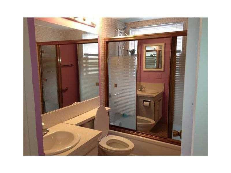 319 Mansfield H, Unit 319 Boca Raton, FL 33434 - Photo 4 of 6 a bathroom with a sink a toilet and shower
