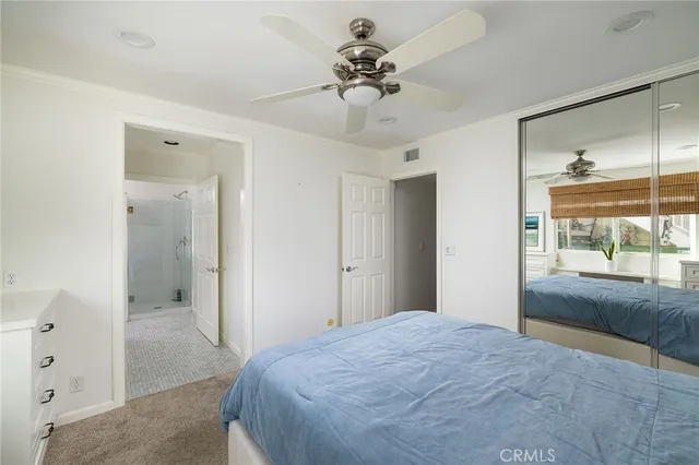 a bedroom with a bed and a chandelier fan