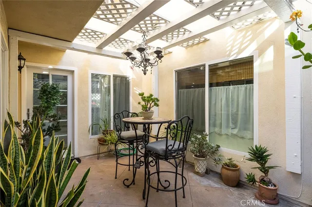 a view of a porch with a table and chairs and potted plants