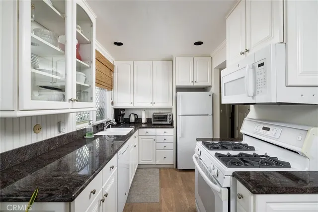 a kitchen with stainless steel appliances granite countertop a stove sink and cabinets