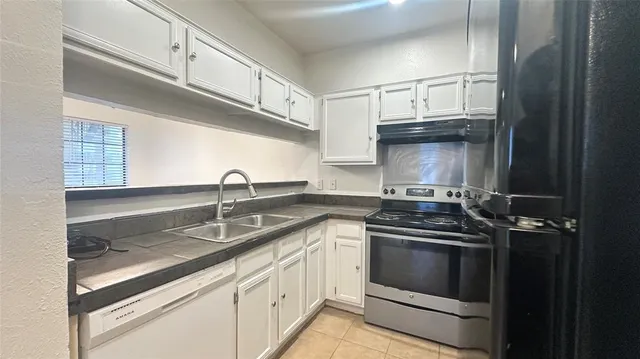 a kitchen with stainless steel appliances granite countertop a sink stove and cabinets