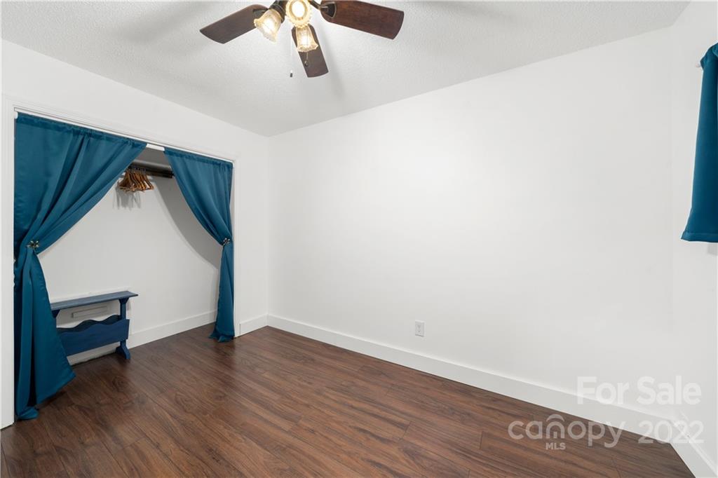 37 Country Road Clyde, NC 28721 - Photo 41 of 46 an empty room with wooden floor and fan