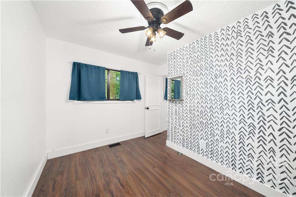 37 Country Road Clyde, NC 28721 - Photo 42 of 46 an empty room with wooden floor and ceiling fan