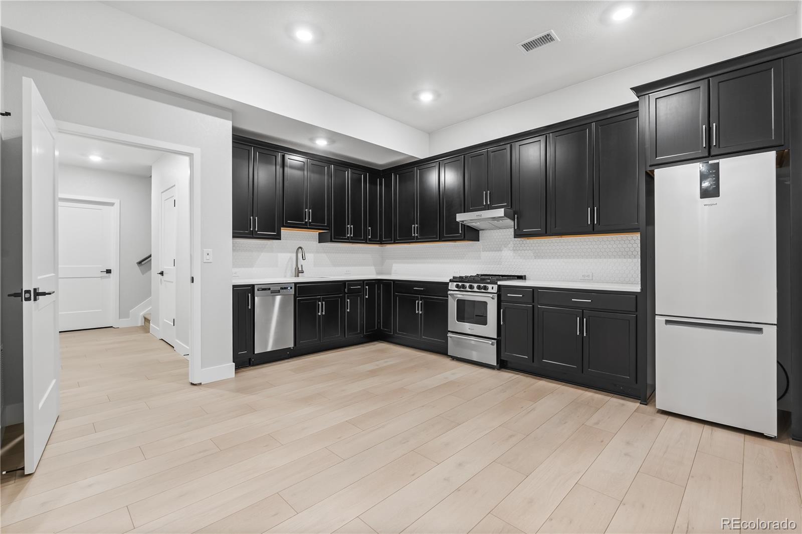 12051 Amplify Circle Lone Tree, CO 80134 - Photo 24 of 34 a kitchen with kitchen island a cabinets and white appliances