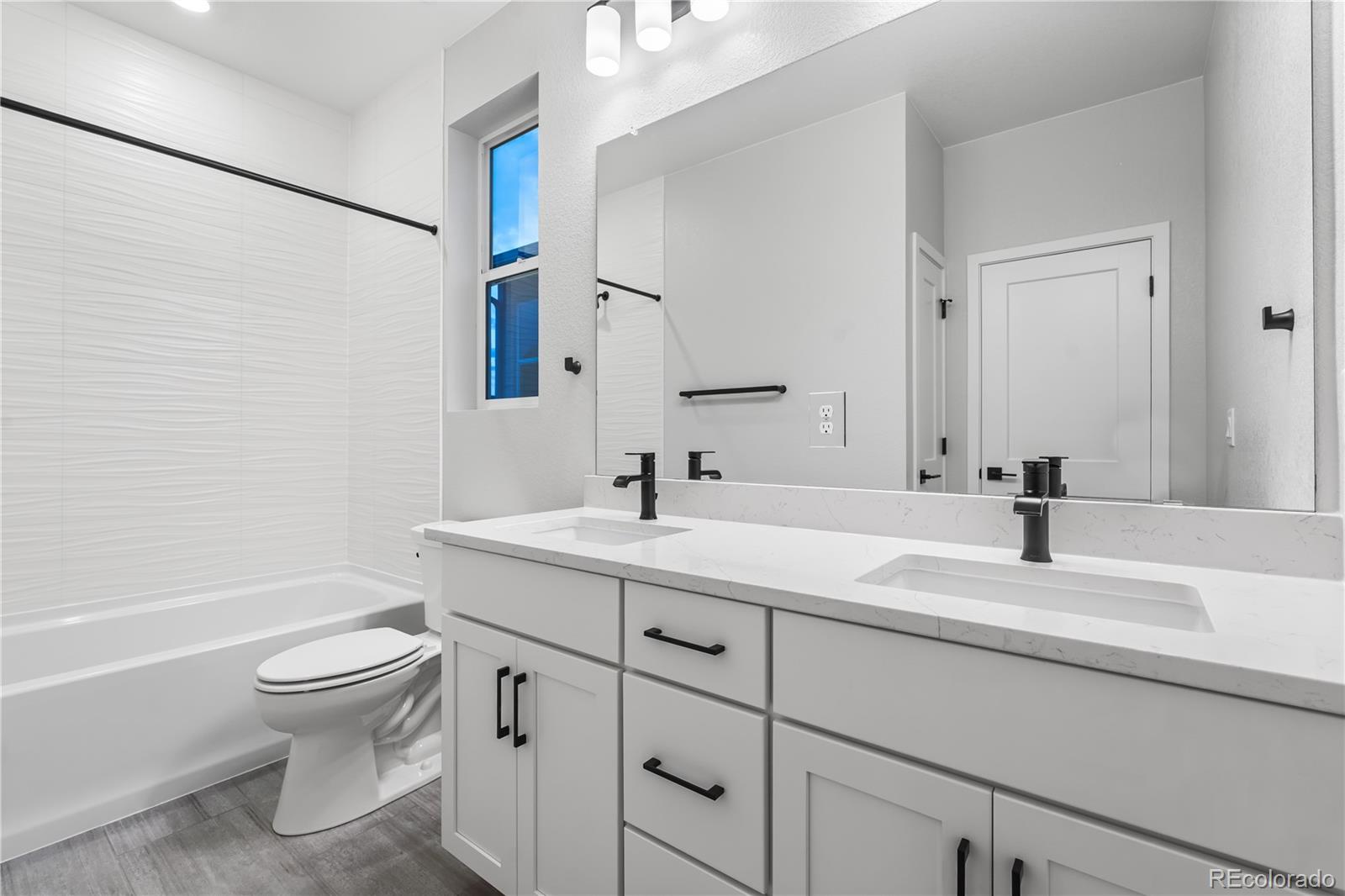 12051 Amplify Circle Lone Tree, CO 80134 - Photo 27 of 34 a bathroom with a sink a toilet and a large mirror