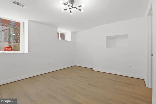 an empty room with a window and ceiling fan