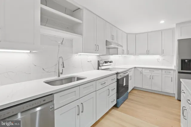 a kitchen with white cabinets sink and white appliances