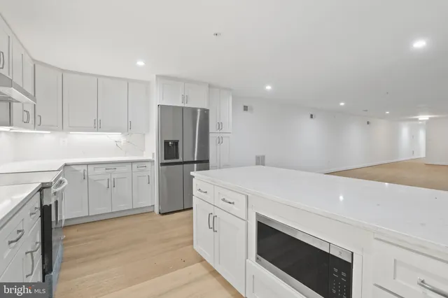 a kitchen with white cabinets and white appliances