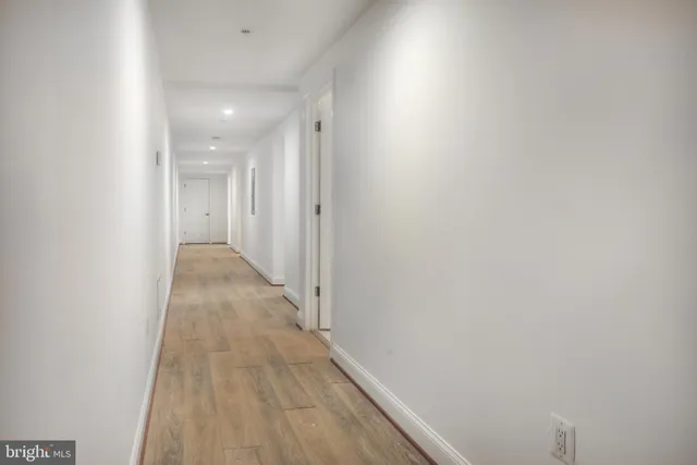 a view of a hallway with wooden floor