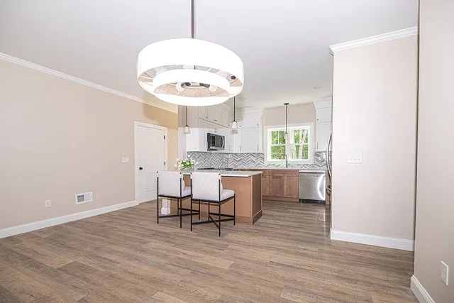 a kitchen with a refrigerator and stools