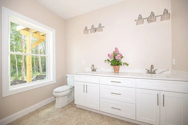 a bathroom with a granite countertop sink mirror and a window