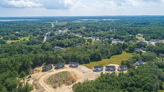 an aerial view of residential house with outdoor space and trees all around