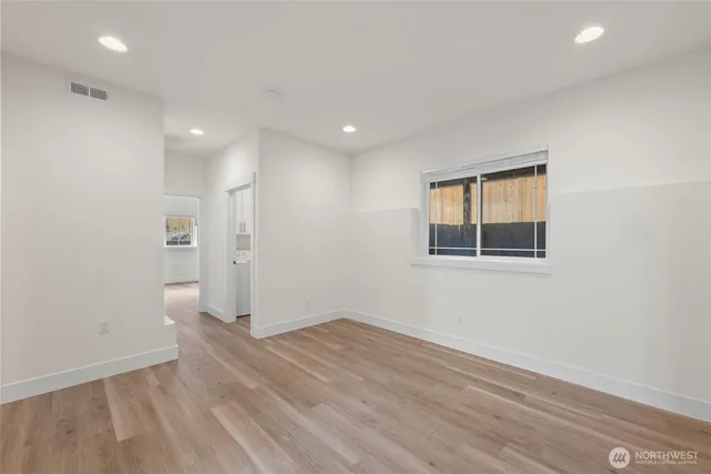an empty room with wooden floor and entryway