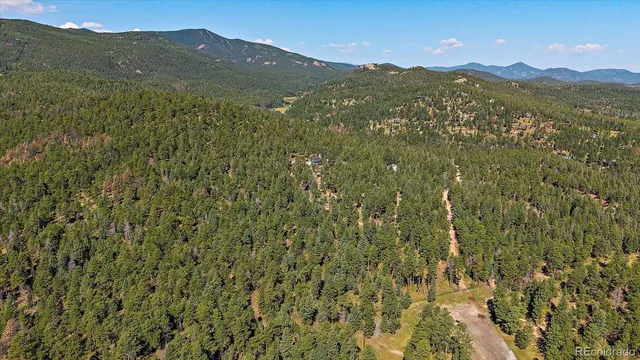 a view of a mountain range with lush green forest