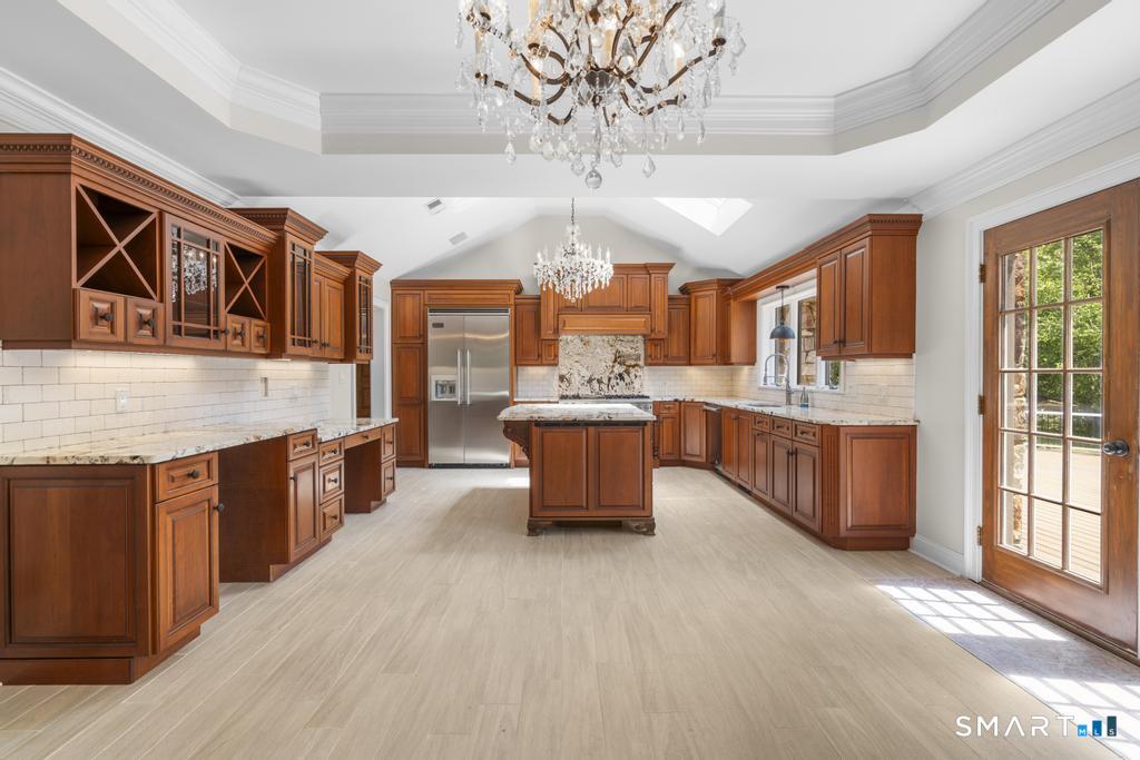 49 Partridge Lane Middletown, CT 06457 - Photo 11 of 39 a large kitchen with stainless steel appliances granite countertop a stove a sink dishwasher a dining table and chairs with wooden floor