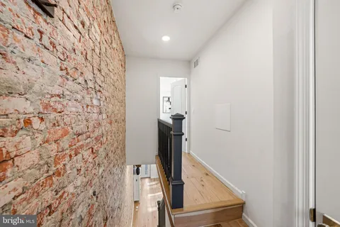 a view of a hallway with wooden floor and entryway