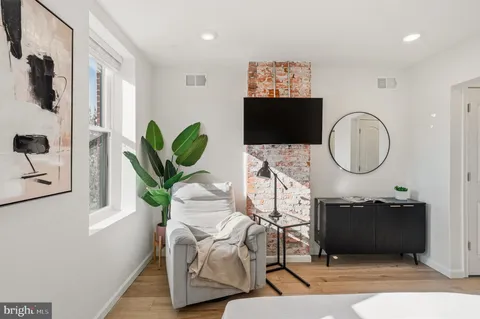 a living room with furniture a mirror and a flat screen tv
