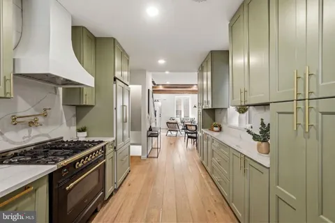 a kitchen with stainless steel appliances granite countertop a stove a sink and a refrigerator