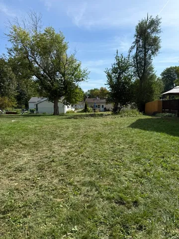 a view of a field with trees in the background