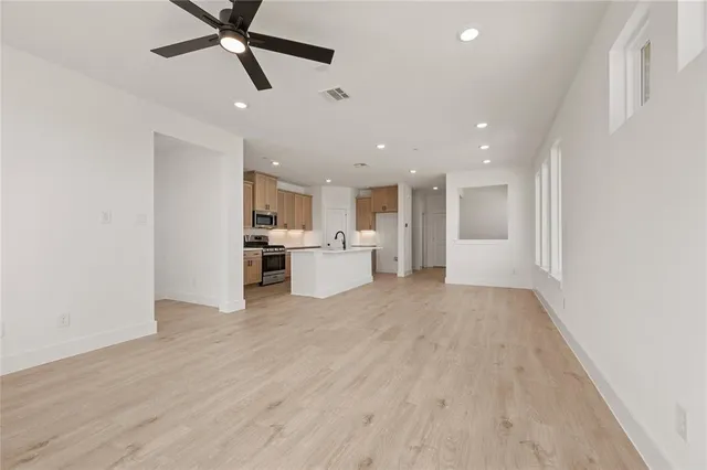 a view of a kitchen with a sink and dishwasher a refrigerator with wooden floor