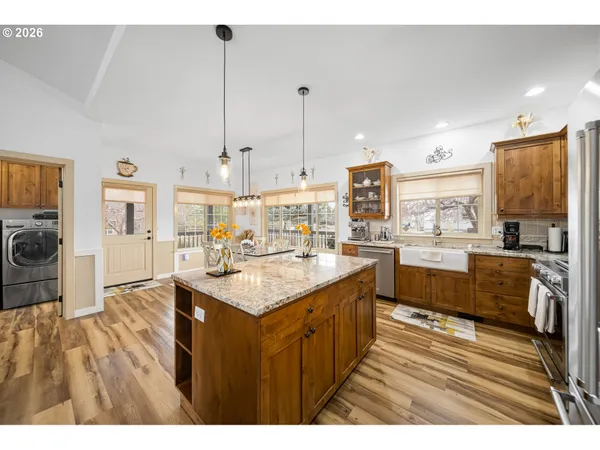 a large kitchen with kitchen island a sink stainless steel appliances and cabinets