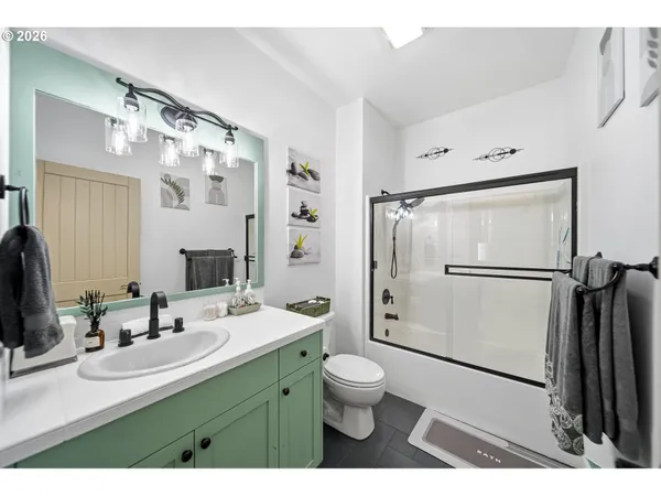 a bathroom with a double vanity sink toilet mirror and shower