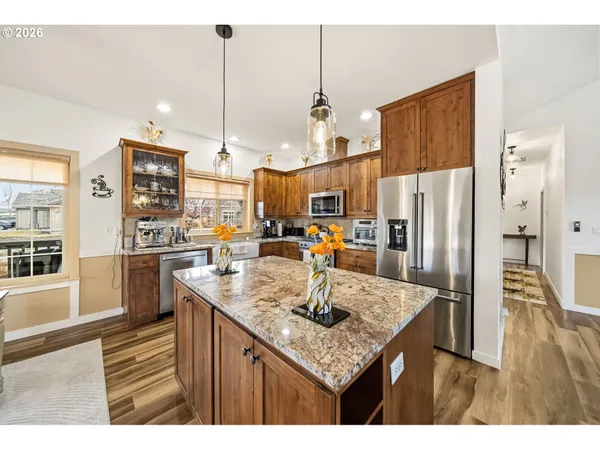 a kitchen with stainless steel appliances granite countertop a sink refrigerator and cabinets