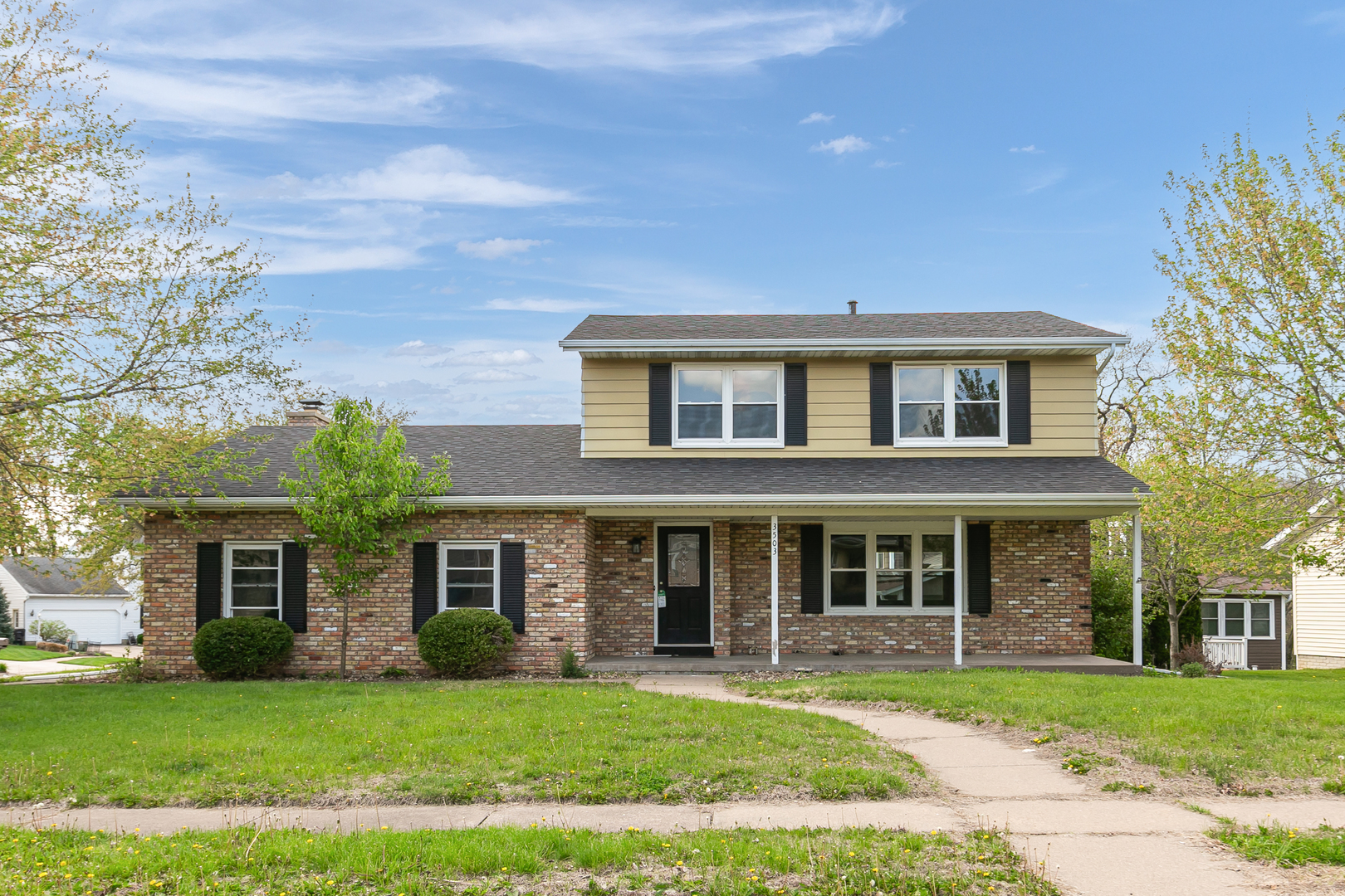 front view of a brick house with a yard
