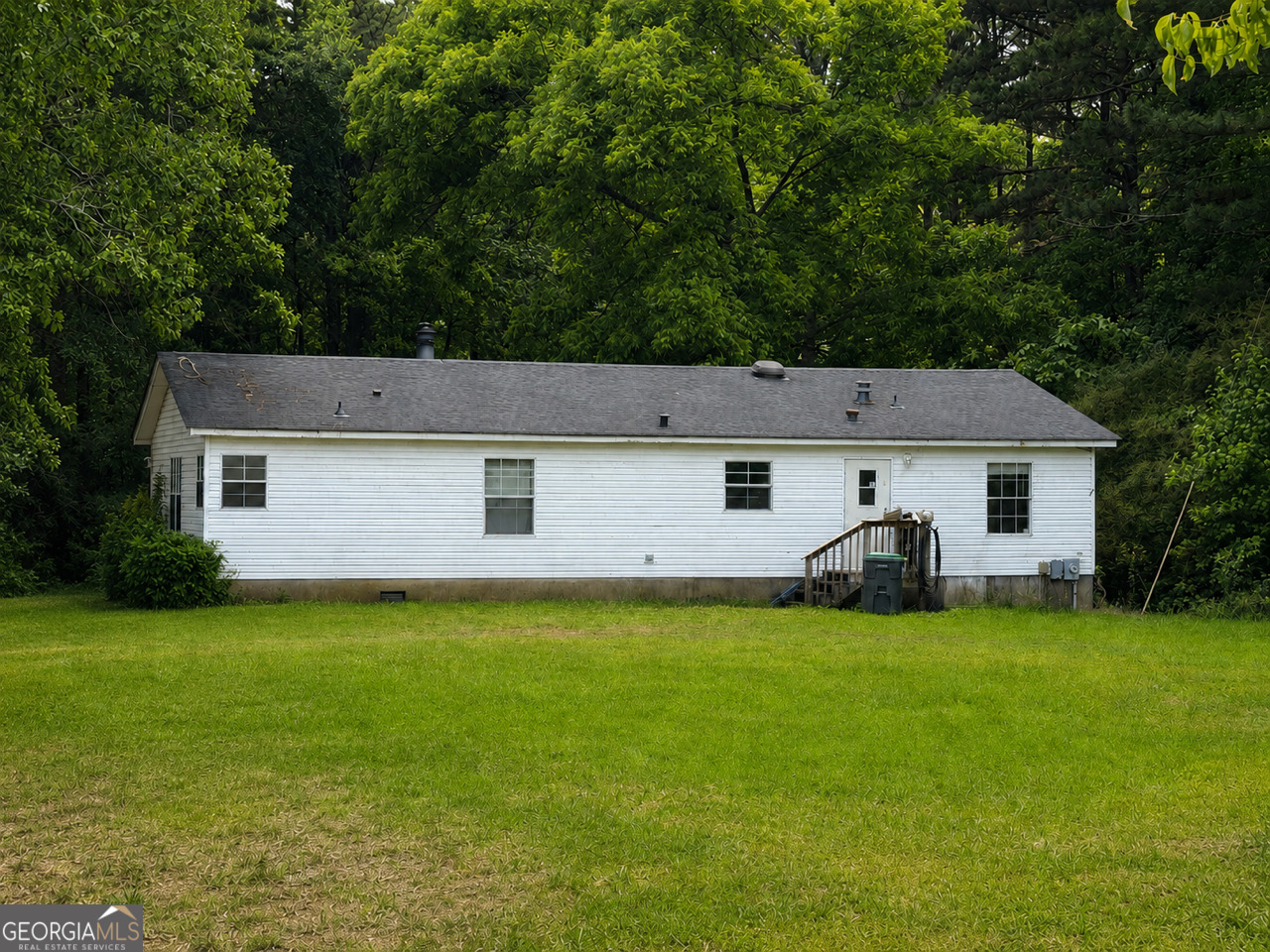 a front view of a house with yard and trees