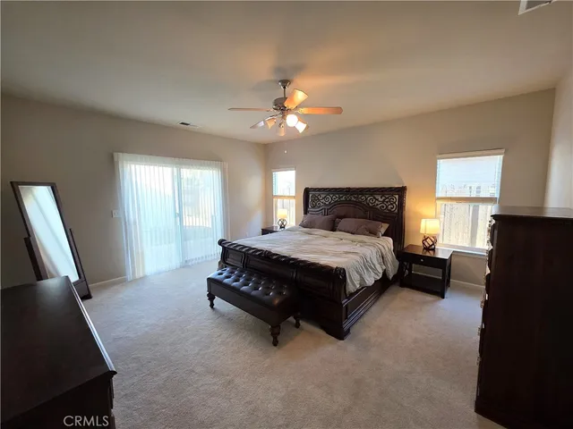 a spacious bedroom with a bed and a chandelier
