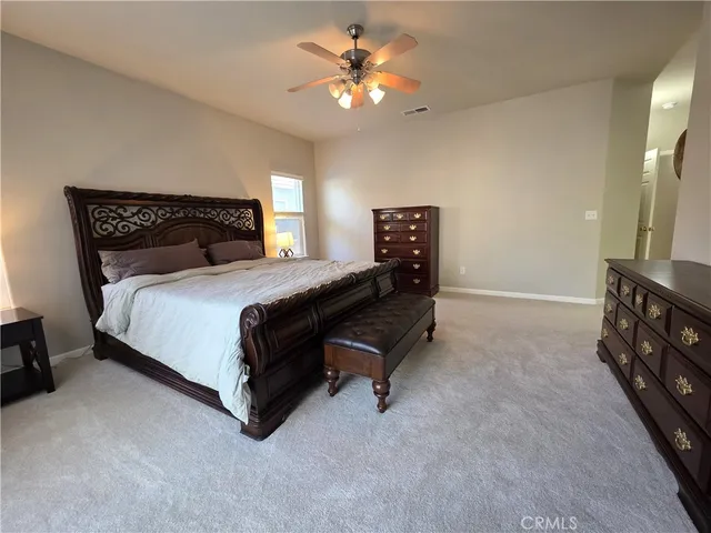 a bedroom with a bed and a ceiling fan