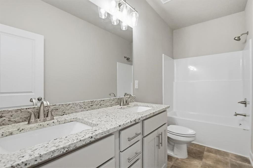 4057 Links Boulevard Jefferson, GA 30549 - Photo 19 of 58 a bathroom with a granite countertop sink toilet and shower