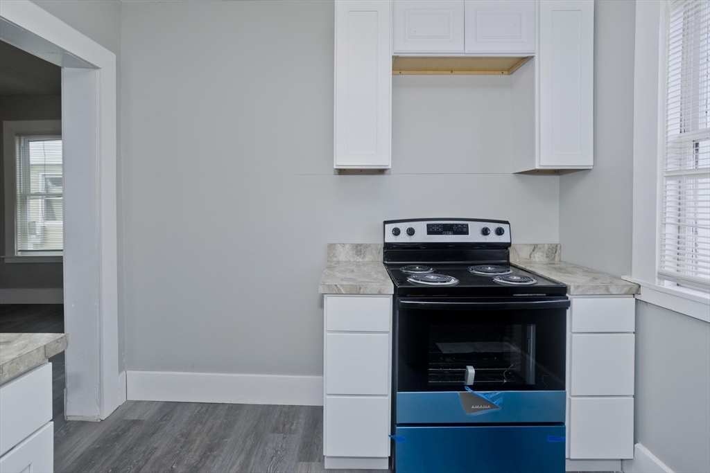 65 Montrose Street Springfield, MA 01109 - Photo 16 of 27 a kitchen with granite countertop white cabinets and stainless steel appliances