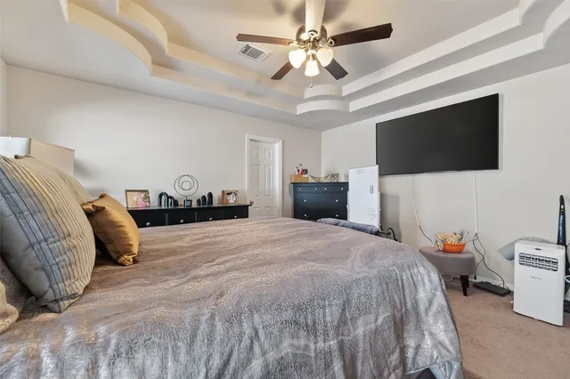 a spacious bedroom with a bed and a flat screen tv