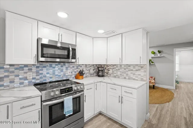 a kitchen with stainless steel appliances granite countertop a stove a sink and a microwave