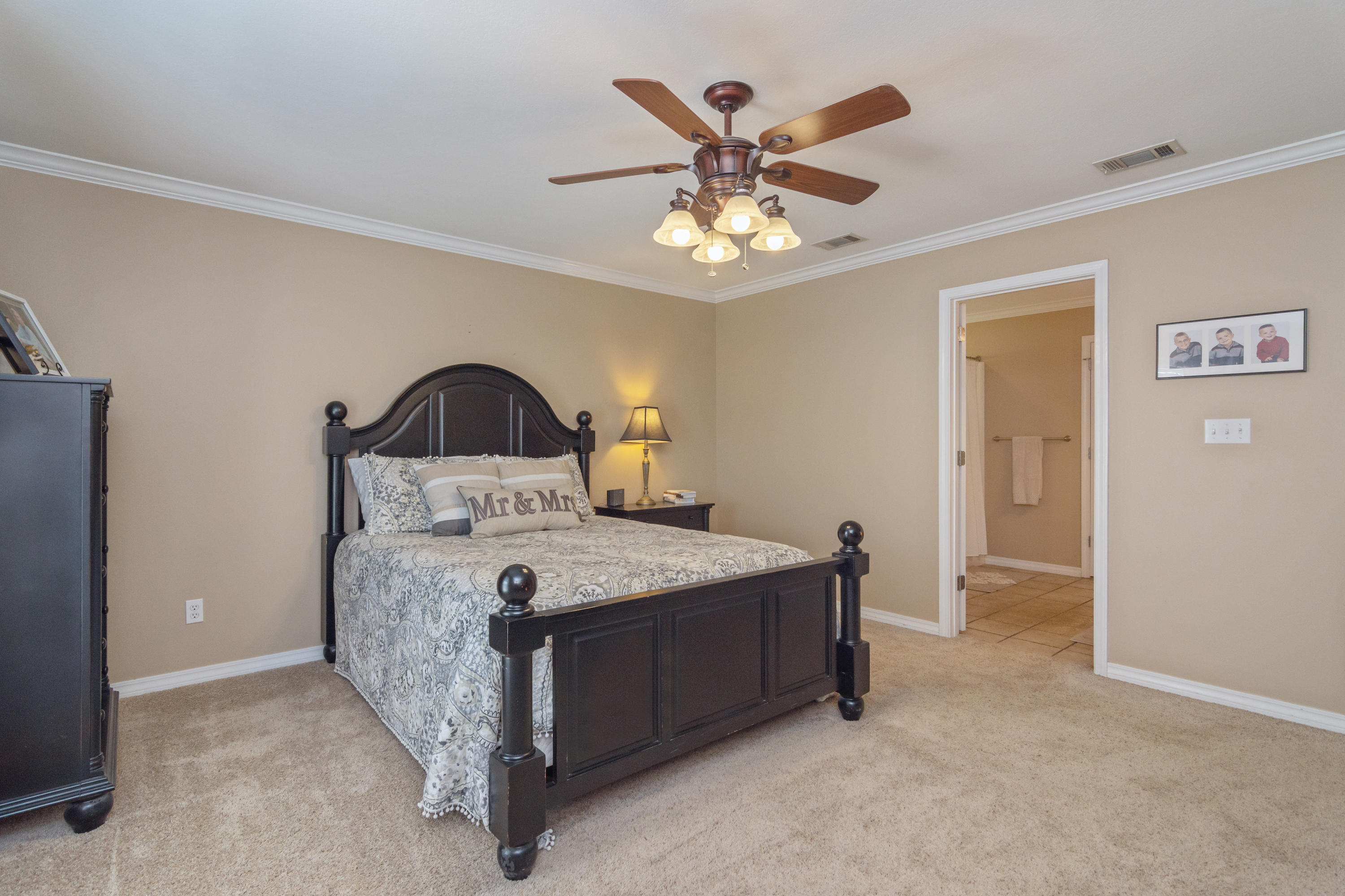 5803 Bush Road Baker, FL 32531 - Photo 19 of 34 a spacious bedroom with a bed and a chandelier